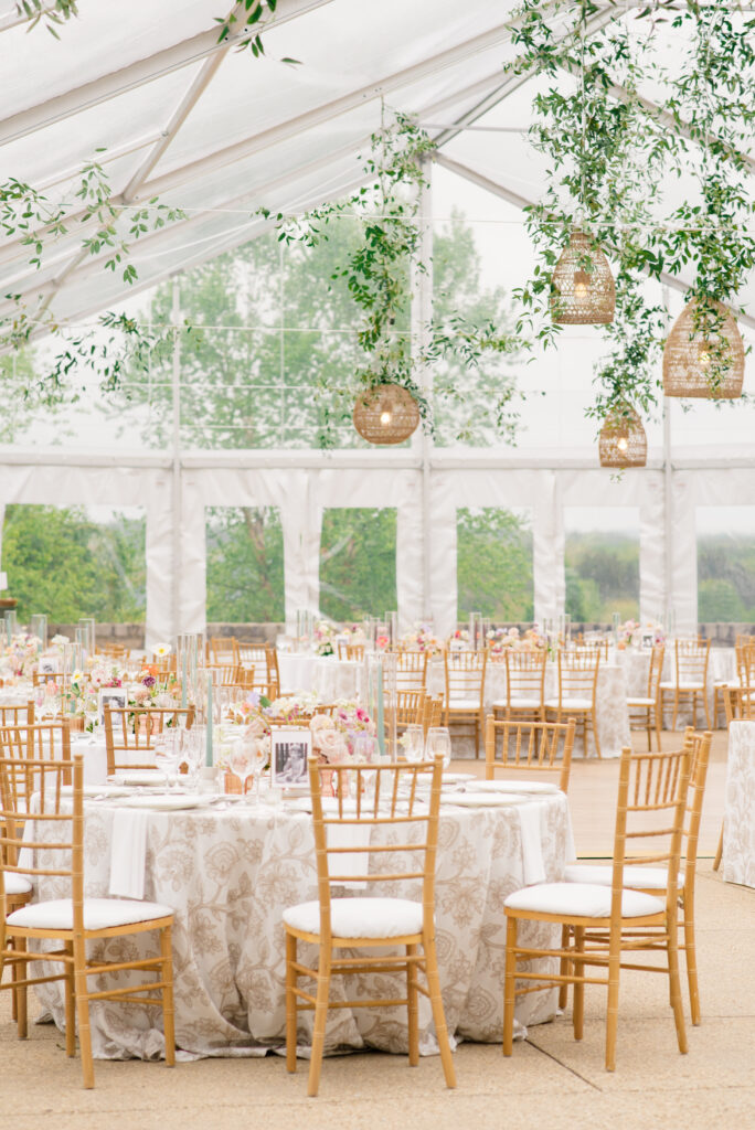 Virginia Beach tented garden wedding venue with gossamer florals and rattan chandeliers with greenery