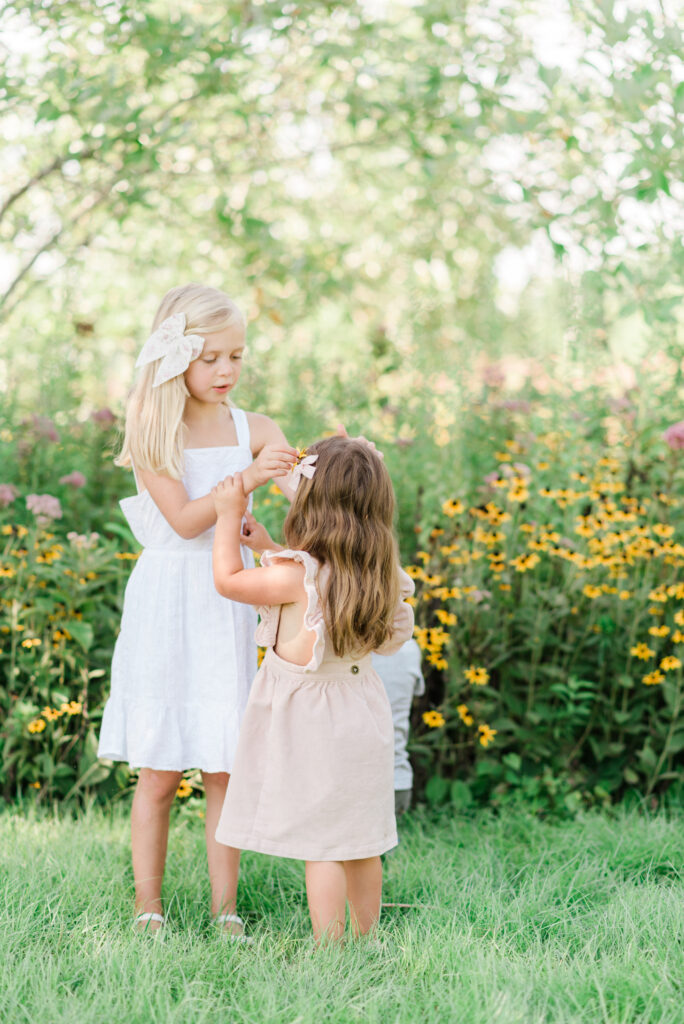 Sisters playing in the gardens at Colonial Williamsburg, Virginia during summer family photos