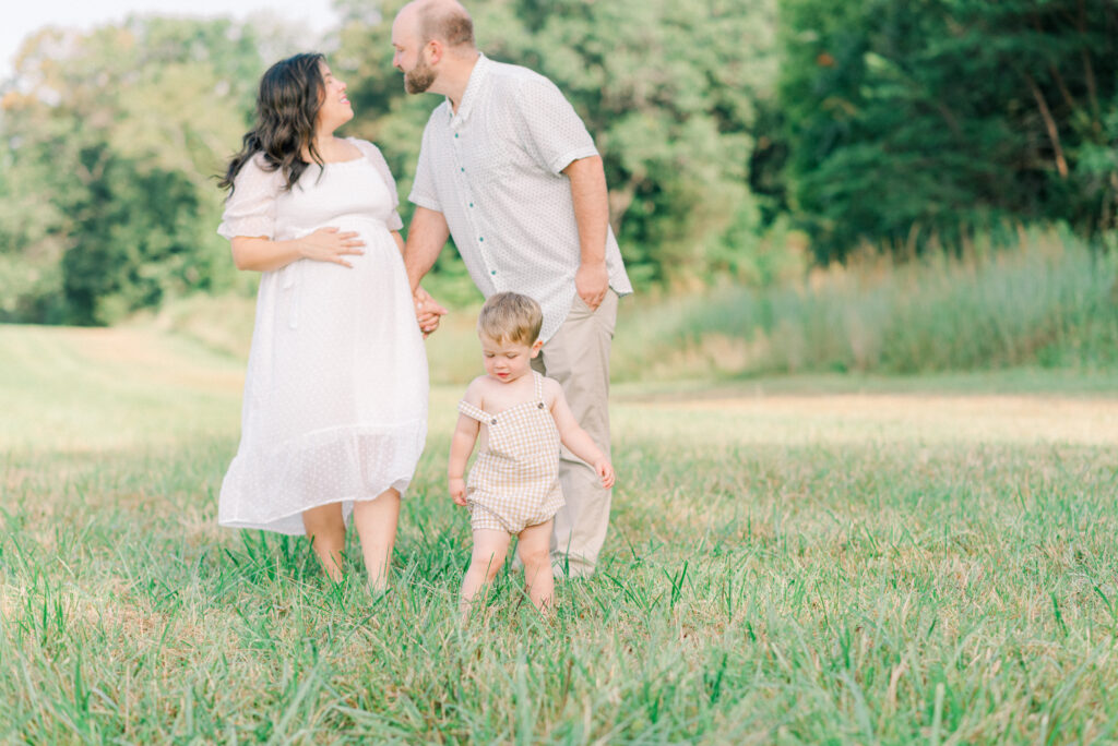 Family playing in a field during their summer maternity photo session in Virginia Beach, VA