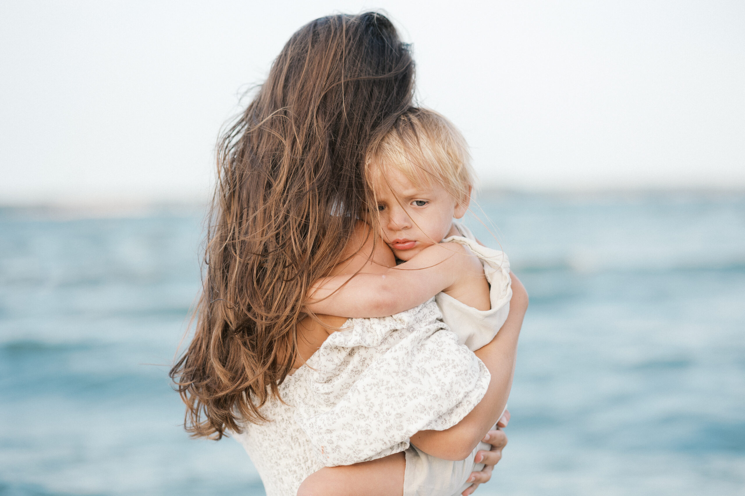 Shannon Roselius, Virginia Beach Photographer, holding her baby by the water