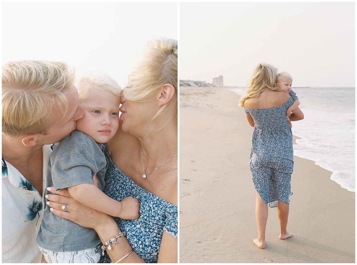 Mom and dad kissing baby and walking along the beach