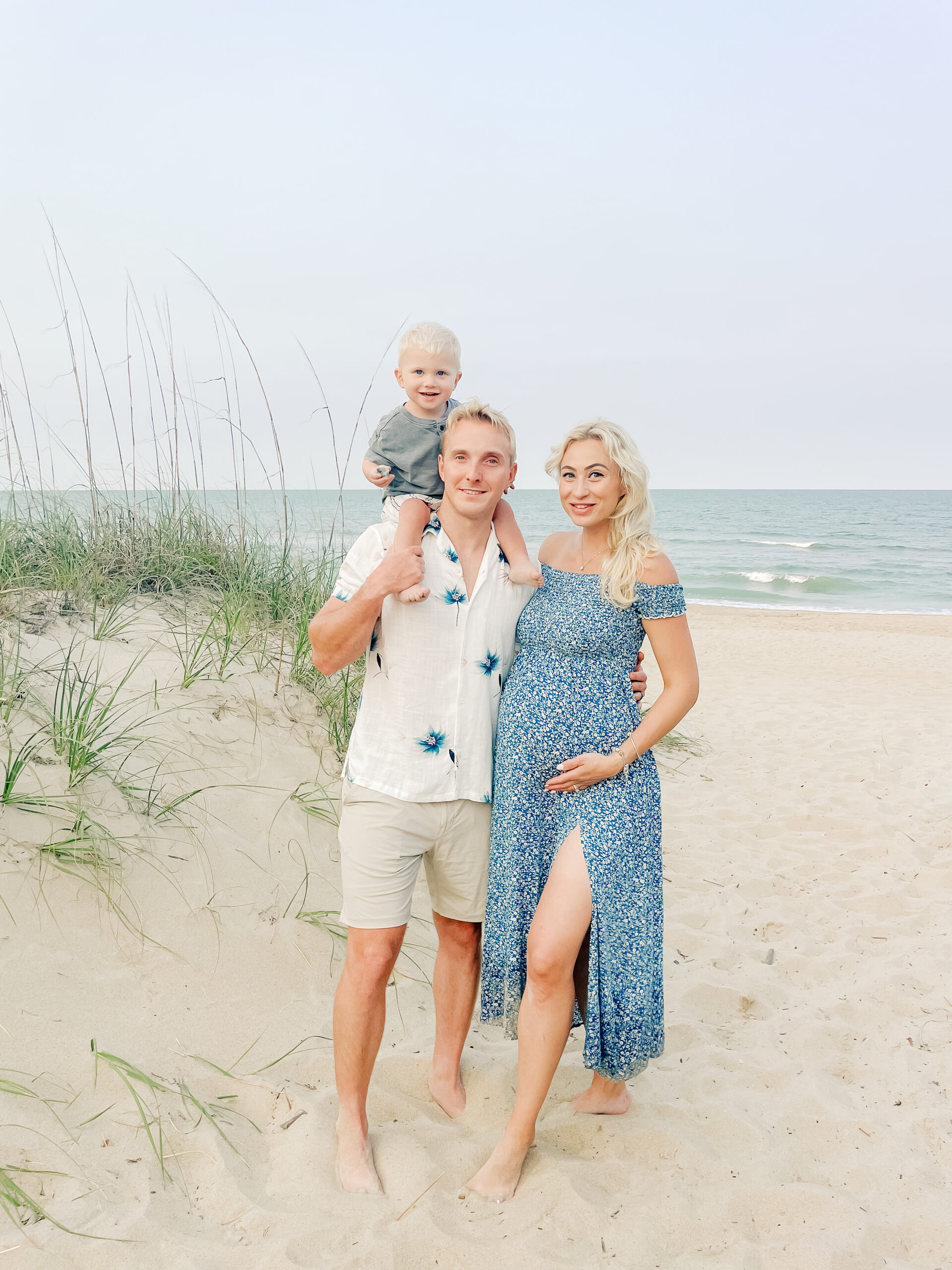 Virginia beach sunset maternity session with family wearing shades of blue and beige